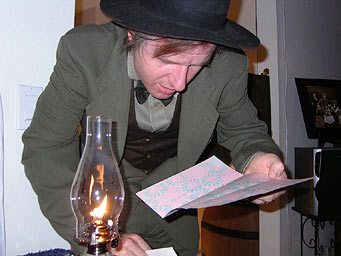 Doug reads a Secret Clue by lamplight