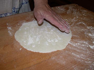 Patting the lefse round with flour