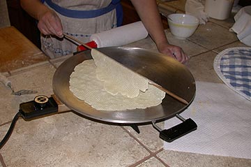 Turning the lefse with the two-edged stick