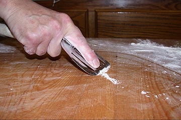 Scraping the dough off the breadboard