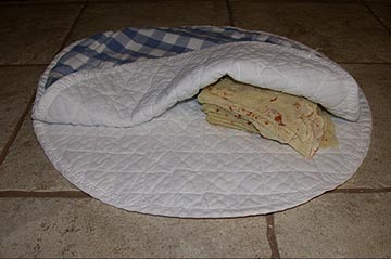 Freshly-made lefse kept in cloth from drying out